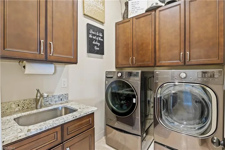 Functional yet stylish laundry area with rich wood cabinetry, and sink, perfect for everyday tasks.