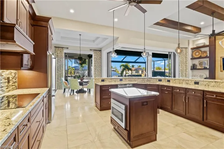 Gourmet kitchen with granite countertops, custom wood cabinetry, and a large breakfast bar, designed for both style and functionality.