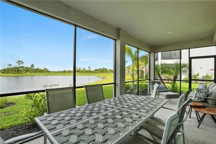 Sunroom with a water view and outdoor dining space