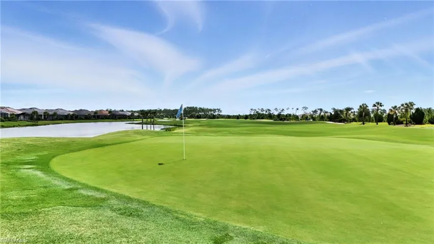 View of community with golf course view, a water view, and a putting green