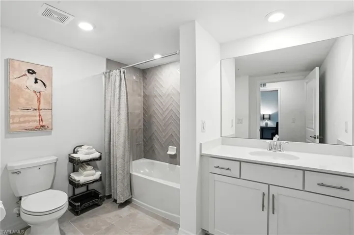 Bathroom with vanity, shower / bath combo with shower curtain, and recessed lighting