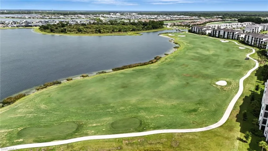 Aerial view of residential area with a golf club and a nearby body of water