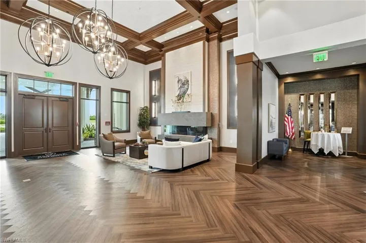 Community lobby featuring a towering ceiling, coffered ceiling, ornamental molding, and beamed ceiling