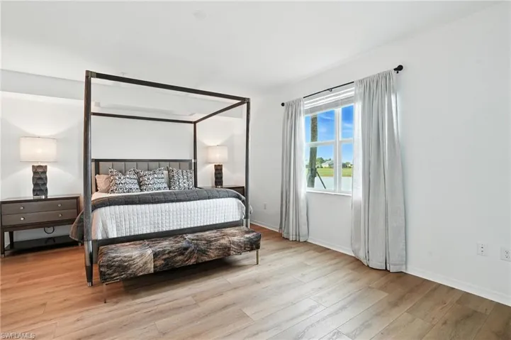 Bedroom with light wood finished floors and baseboards