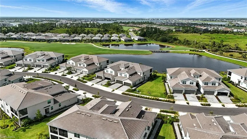 Aerial view of residential area featuring a large body of water and a golf club