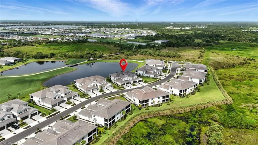 Aerial view of property and surrounding area featuring nearby suburban area and a large body of water