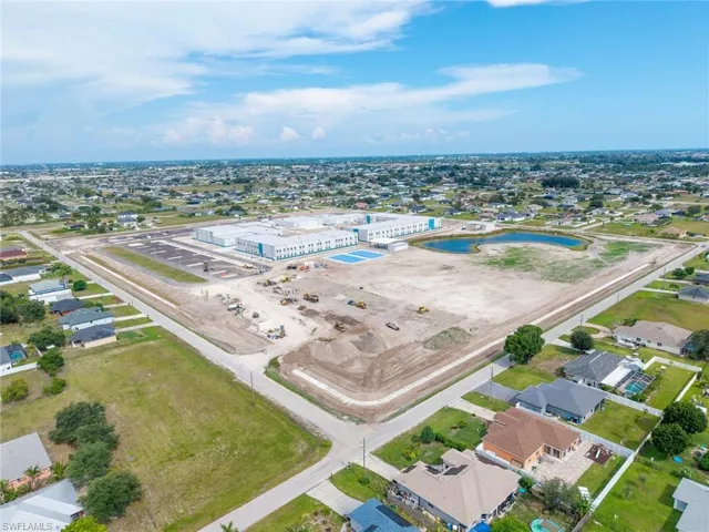 Expansive lot featuring a water retention pond and proximity to a large institutional building
