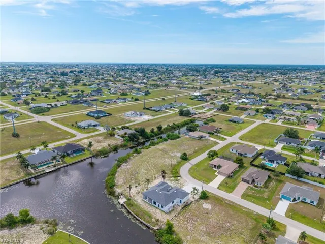 Expansive aerial overview of a residential area featuring multiple single-story homes, many with private swimming pools