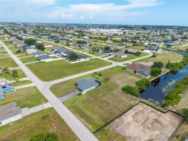 Vacant land parcel featuring a cleared building site, direct canal access, and partially treed surroundings