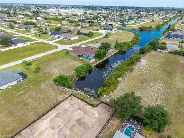 Aerial parcel featuring a water frontage, established neighborhood setting, surrounding residential properties, and a clear, level building site