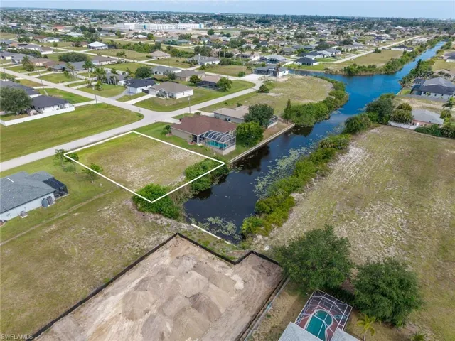Vacant land parcel featuring canal frontage, clear lot, and street access