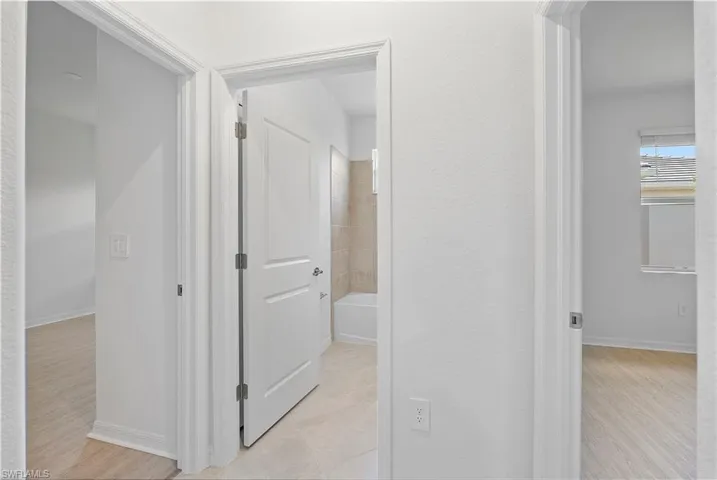 Hallway featuring light tile floors