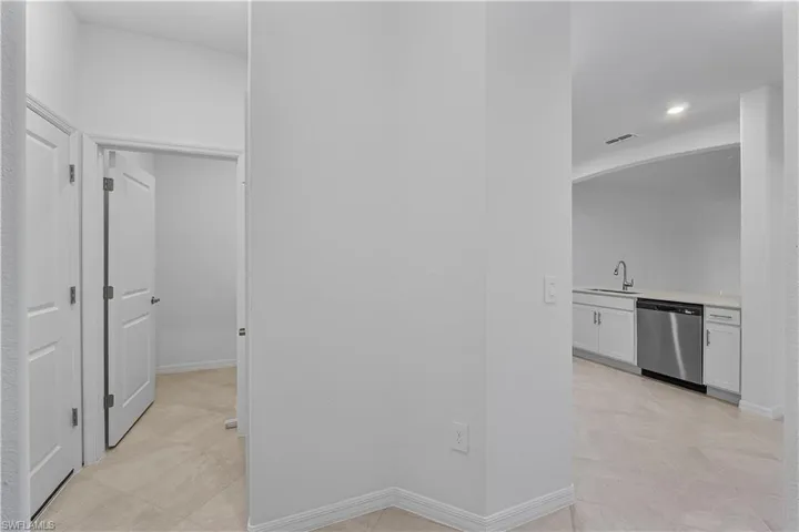 Hallway featuring sink and light tile flooring