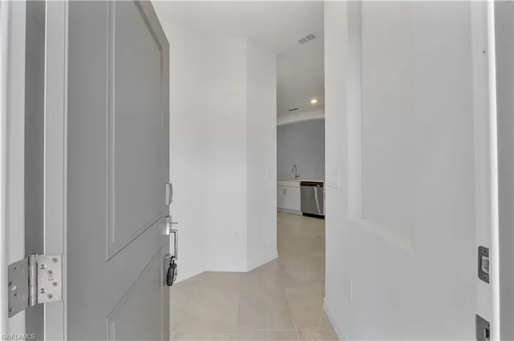 Hall with sink and light tile floors
