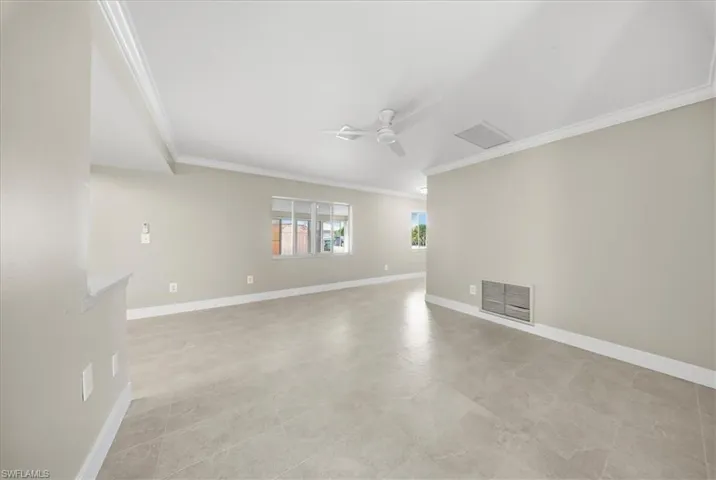 Unfurnished room featuring crown molding and a ceiling fan