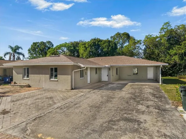 Ranch-style home featuring driveway, roof with shingles, and stucco siding