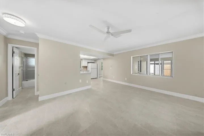 Unfurnished living room with ornamental molding and ceiling fan