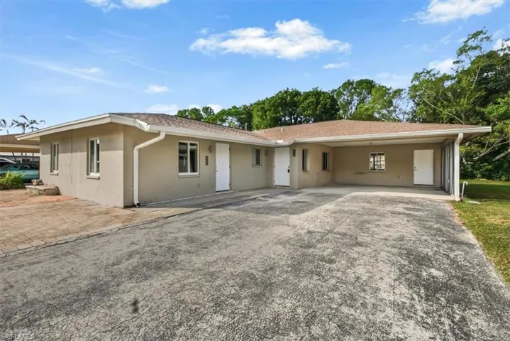 Ranch-style home with stucco siding, driveway, and an attached carport