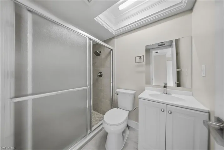 Bathroom featuring vanity, a shower stall, and ornamental molding