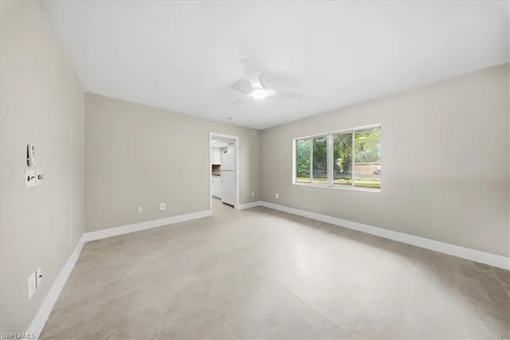 Empty room featuring baseboards and a ceiling fan