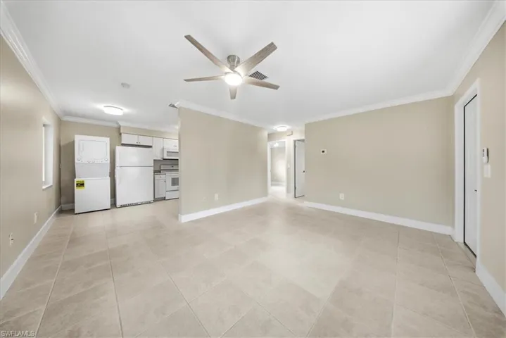 Second Unit-Unfurnished living room with a ceiling fan, ornamental molding, and stacked washer / drying machine