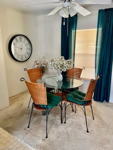 Dining area with carpet flooring and a ceiling fan