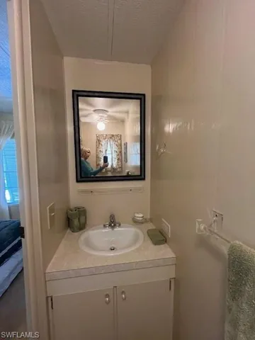 Bathroom with vanity, ensuite bathroom, and a textured ceiling
