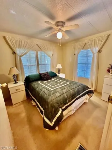 Bedroom featuring carpet, a textured ceiling, and a ceiling fan
