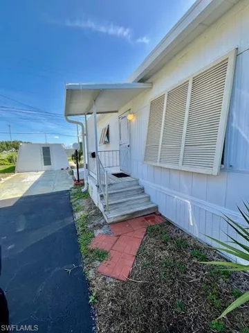 View of side of home featuring asphalt driveway