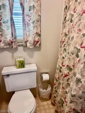 Bathroom with toilet and curtained shower