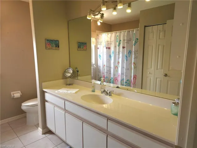 Bathroom featuring tile flooring, sleek wide vanity with a single sink, but plenty of room for a 2nd sink, if desired. Additionally, this bathroom has it's own linen closet, and there is another closet outside in the hall!