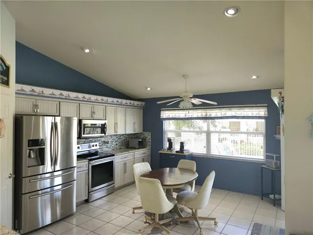 Eat-in Kitchen with ceiling fan, lofted ceiling, tile flooring and stainless steel appliances