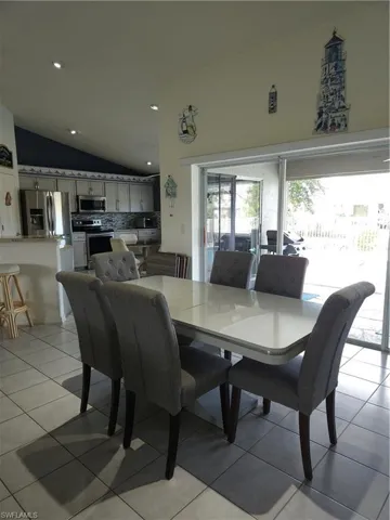 Dining space featuring lofted ceiling and light tile patterned floors