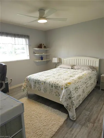 Queen-sized bedroom #2 with ceiling fan, double-wide closet, laminated wood-style plank flooring