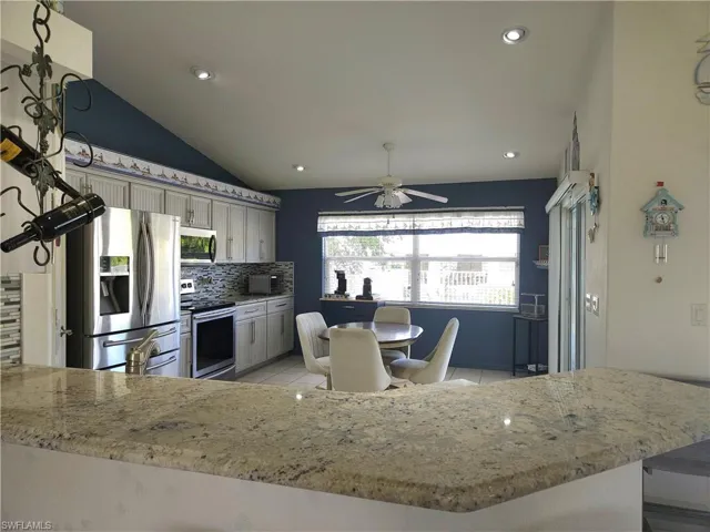 This cheerful eat-in kitchen overlooks the backyard and pool and has a slider to the covered lanai