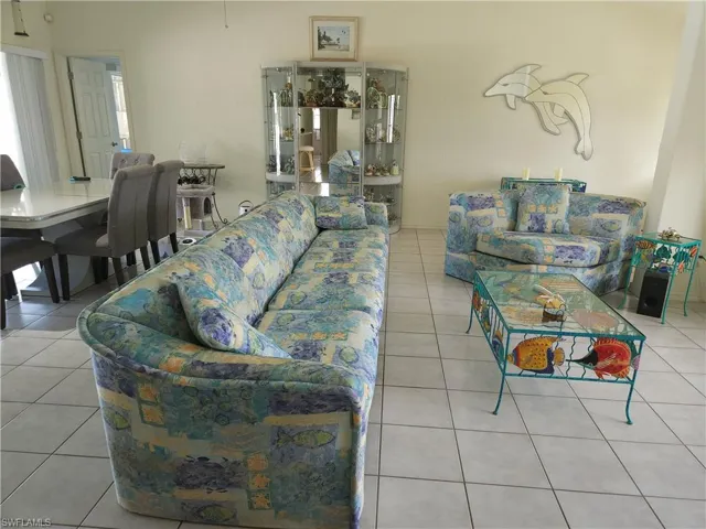 Another view of the living room with a wealth of natural light and light tile flooring.