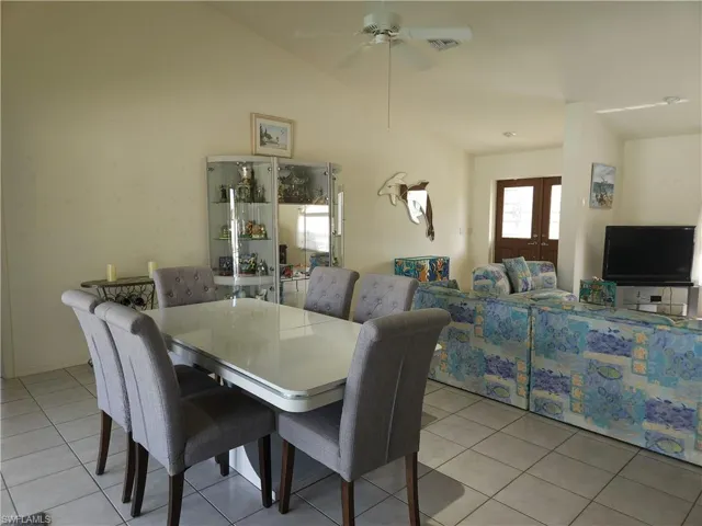 The dining area is adjacent to a long wall of sliders overlooking the expansive covered lanai and is perfect for entertaining guests both inside and outdoors.