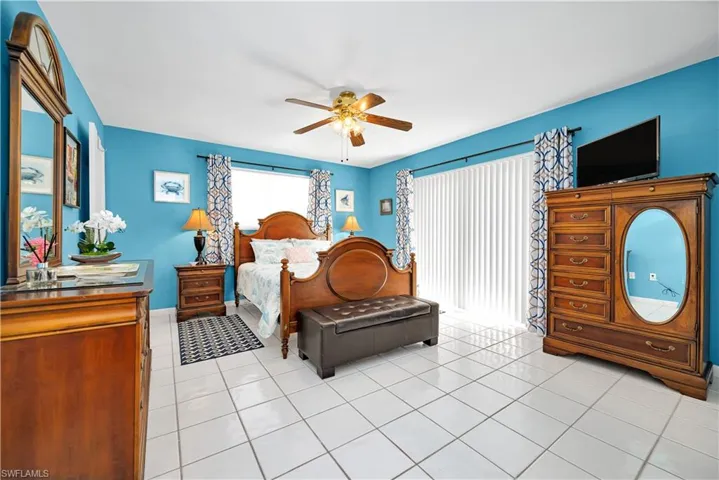 Tiled bedroom featuring ceiling fan