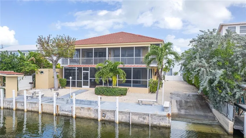 Rear view of house featuring a sunroom and a water view