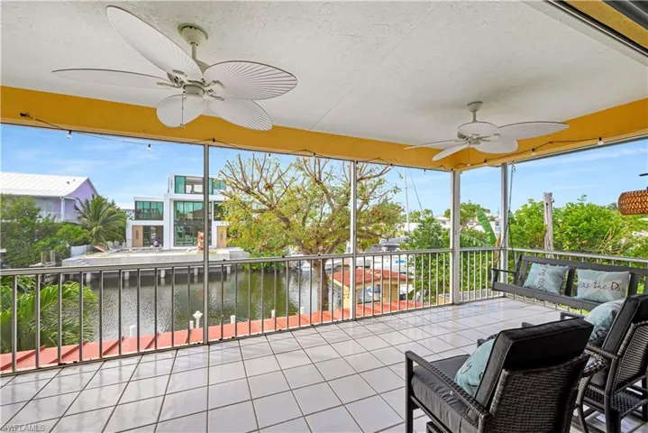 Sunroom / solarium with ceiling fan, a healthy amount of sunlight, and a water view