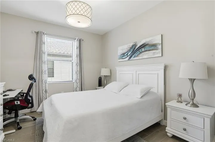 Bedroom with wood finish floors and an office area