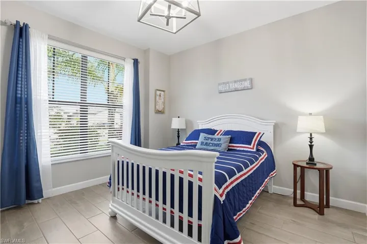 Bedroom with wood tiled floors and suspended lighting