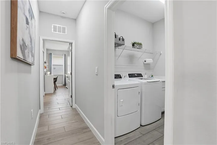 Laundry area with wood tiled floors and independent washer and dryer