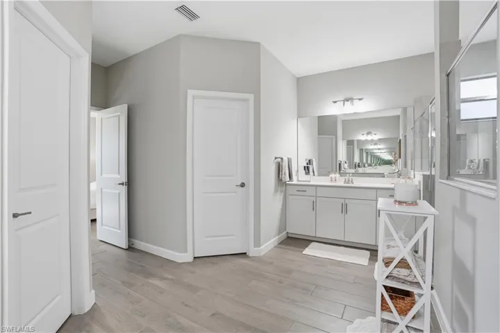 Full bathroom featuring vanity, light wood-type flooring, and an enclosed shower