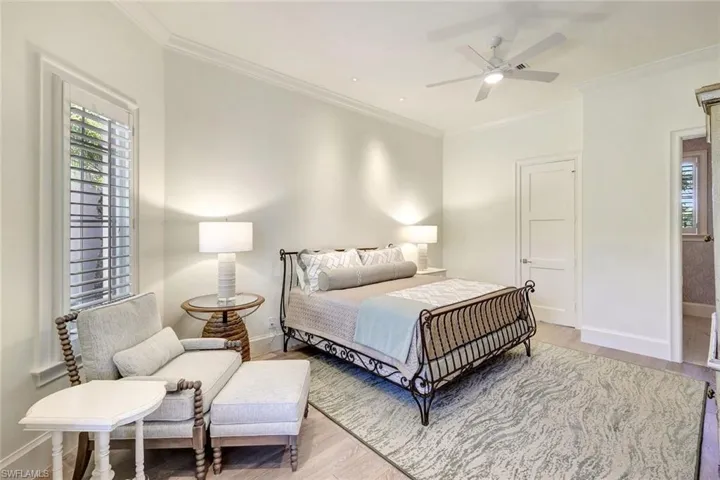 Bedroom featuring hardwood / wood-style floors, ceiling fan, and ornamental molding