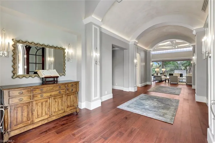 Hall featuring dark hardwood / wood-style flooring and vaulted ceiling