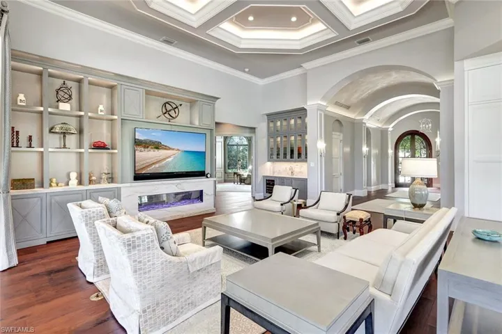 Living room with beam ceiling, dark hardwood / wood-style flooring, coffered ceiling, and ornamental molding