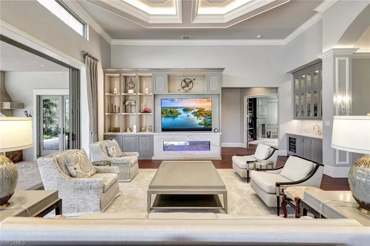 Living room with hardwood / wood-style floors, indoor bar, french doors, and crown molding