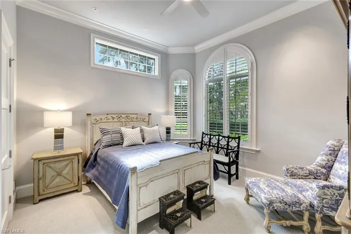 Bedroom featuring light colored carpet, ceiling fan, and ornamental molding