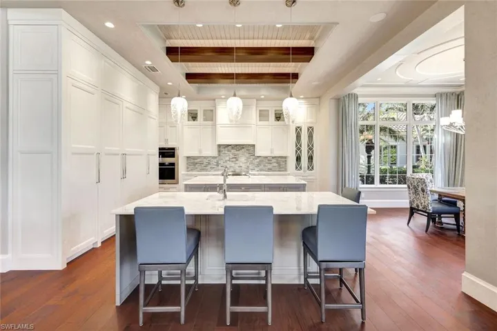 Kitchen featuring dark hardwood / wood-style flooring, hanging light fixtures, and an island with sink